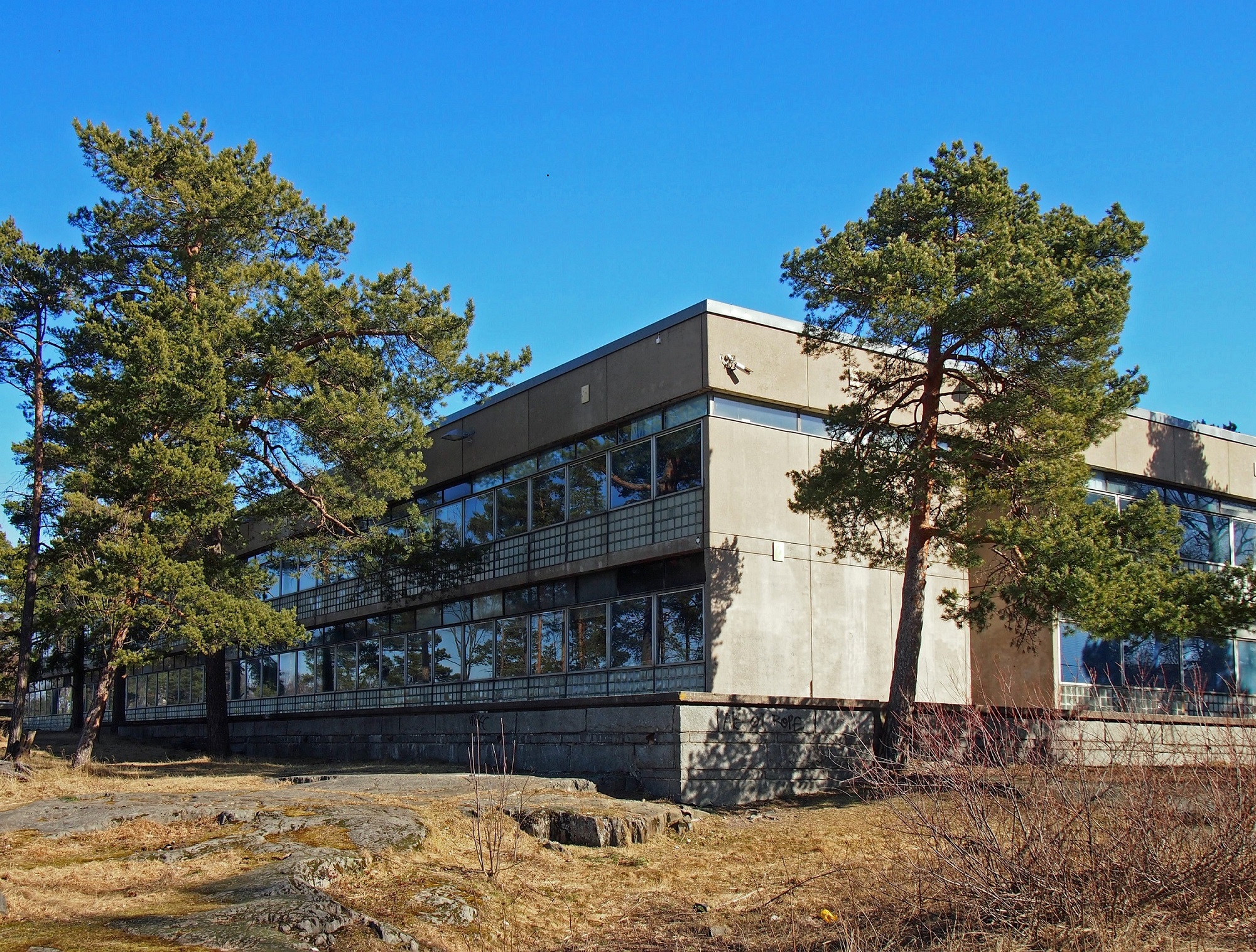 Roihuvuoren alakoulu liittyy luonnontilaiseen kalliomaastoon Roihuvuoren rinteessä.