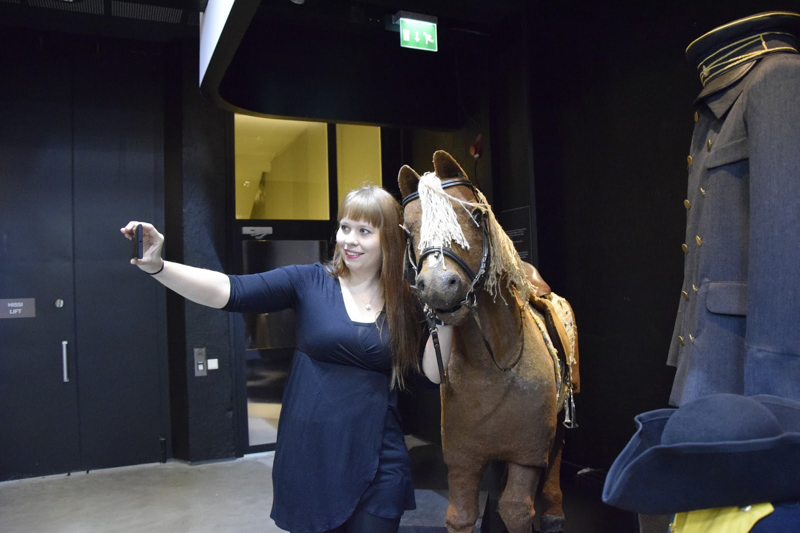 Sallamari Kuusela ottamassa selfietä Postimuseon tiloissa mobiilipostikortin lähettämistä varten.